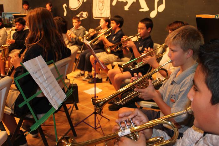 A long row of trumpet playing students in band class