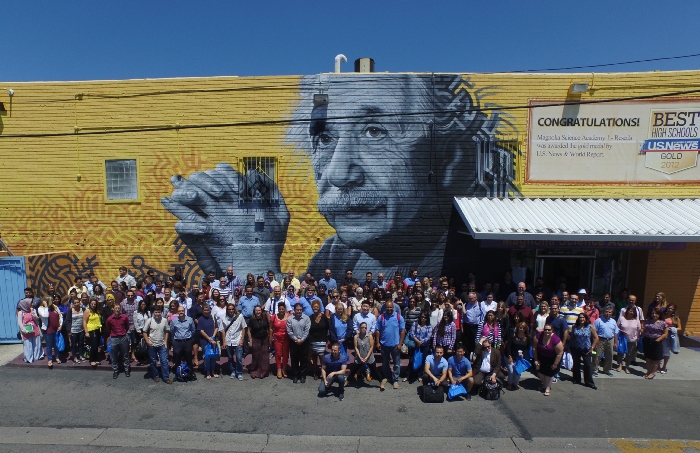 Large group of students in front on an Albert Einstein mural on an outside building's wall